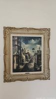 Full view of framed oil painting of urban street scene.
