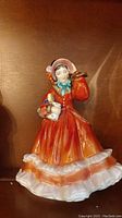 Front and side views of Royal Doulton Christmas Time figurine showing detailed dress and accessories