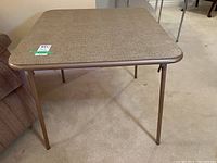 Front angled view of the vintage card table showing the vinyl tabletop and metal legs.
