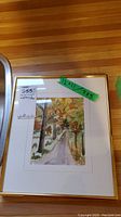 Full view of larger framed watercolour painting with label showing measurements 12x11 and 7x5