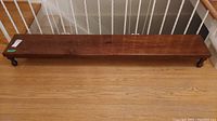Full length photo of the wooden bench showing its size and finish.