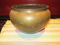 Front view of large round copper planter showing overall shape and patina.