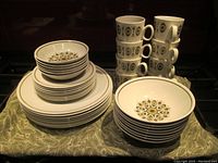 Full set organized with plates, bowls, and stacked mugs showing the pattern and condition.
