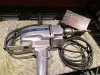 Vintage Eaton Tecomaster Professional 1/2" reversible hammer drill next to Versamatic accessory in original box