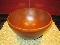 Front view of large vintage teak bowl showing smooth surface and wood grain.