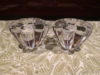 Pair of Orrefors Stella flower-like crystal candlestick holders together, angled to show side profile and thickness of crystal.