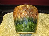 Front view of the large ceramic planter showing the ombre glaze from brown to green and starburst design.
