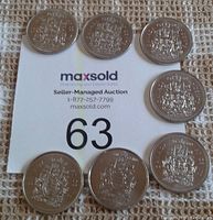 Coins arranged showing the reverse side with the Canadian coat of arms.
