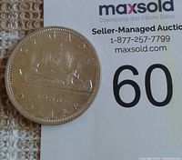 Photo of the reverse side of the 1966 Canada silver dollar coin showing the canoe design and 'CANADA DOLLAR 1966' inscription.