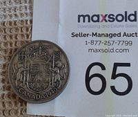 Photo showing obverse side of Canadian half-dollar coin featuring the coat of arms, denomination, and year 1940.