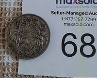 Front side of the 1945 Canadian silver half dollar showing the Canadian coat of arms, denomination, and year.