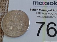 Reverse side of 1961 Canadian silver half-dollar coin displaying the Canadian coat of arms and denomination '50 CENTS'.