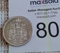 Reverse side of 1965 Canadian silver half-dollar coin featuring the Canadian coat of arms and denomination.