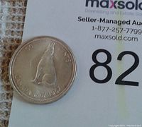 Obverse side of the 1967 Canadian silver half dollar showing the howling wolf and date inscription.