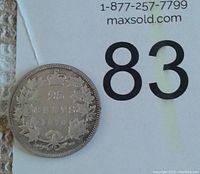 Reverse of the 1870 Canadian silver quarter showing denomination, maple leaves, crown and date.