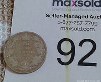 Reverse side of the 1915 silver quarter showing the crowned 25 cents denomination surrounded by a maple leaf wreath and the word CANADA.