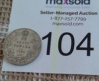 Close-up of reverse side of 1934 Canada silver quarter showing denomination, maple leaf wreath, crown, and year 1934.