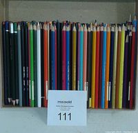 Overhead view of two trays of colored pencils showing variety of colors and brands as labeled.