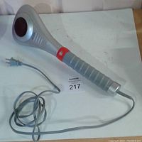 Full view of the Dr Scholls handheld massager showing the entire unit with power cord and handle grip.