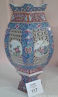 Full front view of the hexagonal porcelain lantern showing handpainted floral and scenic panels with reticulated latticework craftsmanship.