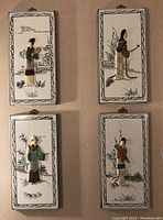 Four wooden plaques mounted on a wall showing Asian style 3D male and female figures, decorative painted backgrounds with bamboo and natural elements.