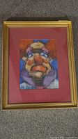 Framed clown artwork by Don Wright showing clown face in multicolor pastel with gold-toned frame and red mat.