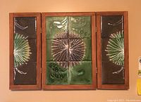 Full view of the tri-fold wood and tile plant art mounted on wall showing central and side panels.