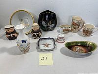 Overview photo showing the collection of porcelain items including the floral vase, black vase, monk figurines, dish, decorative bowl, mugs, and bell.