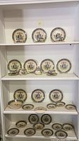 Shelf display of entire set showing plates, bowls, and cups with saucers all featuring the hearts and flowers design.