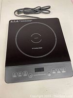 Top view of induction cooktop showing glass panel cooking surface and touch control buttons.