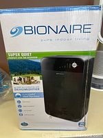 Front of retail box showing Bionaire branding, image of black dehumidifier and key features.
