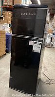 Front view of vinyl black refrigerator with Galanz logo and intact finish.