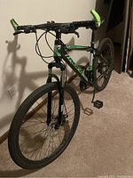 Front-left three-quarter view showing suspension fork, front wheel and frame graphics