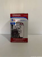 Front of the Omron 5 Series blood pressure monitor box showing the main display of the digital monitor and branding.