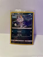Alolan Meowth holographic promo card with details showing moves and HP