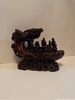 Side view of the full Chinese eight immortals figurine showing the intricate carving of the boat and tree canopy.