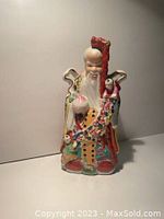 Front view of Chinese God of Longevity porcelain statue showing vibrant colored glaze and symbolic figures.