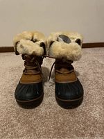 Front view of Crocs women's winter boots with fur lining and lace-up front, showing overall new condition.