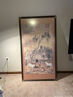 Front view of framed artwork leaning against wall on carpeted floor showing full composition