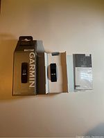 Garmin Vívófit 4 device, original box and quick start manual laid out on flat surface
