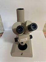 Front view of microscope head and base showing binocular eyepieces