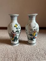 Pair of vintage Chinese porcelain vases standing upright showing colorful figure and floral designs.