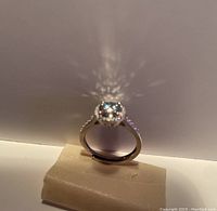 Close-up photo of sterling silver ring with 1 carat moissanite stone displaying its shine and reflective qualities.