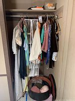 Photo of hanging vintage women's dresses and jackets, various colors and fabrics visible