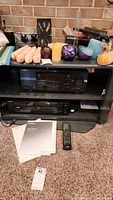 Full media cabinet with Yamaha receiver and Sony CD player inside, and various items on top that are not included