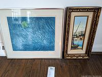 Photo of two framed artworks side by side on the floor, showing overall condition and framing details.
