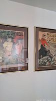 View of both framed vintage posters hanging on wall, showing art and frame style