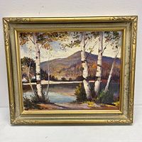 Front view of framed oil painting showing the autumn landscape scene with three birch trees and a mountain lake.