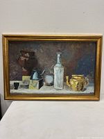 Front view of the framed painting showing abstract still life elements including pots, bottles, and a kettle with muted color palette.
