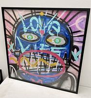 Front view of framed abstract oil painting leaning against a white wall